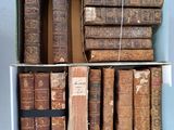 de nombreux livres anciens dans une boîte posée sur une étagère