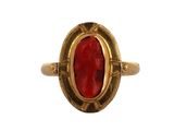 une bague en or avec une pierre rouge au centre