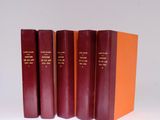 three red books are stacked on top of each other on a white surface