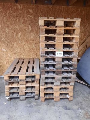 several pallets of wood are stacked on top of each other in a garage