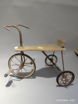un petit tricycle en bois posé sur une table