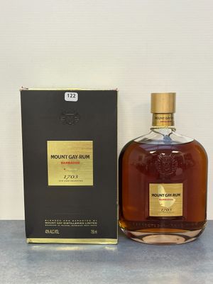 une bouteille de rhum Mount Gay posée à côté d'une boîte sur une table
