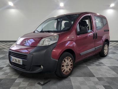 a small red van parked in a room with checkered floor