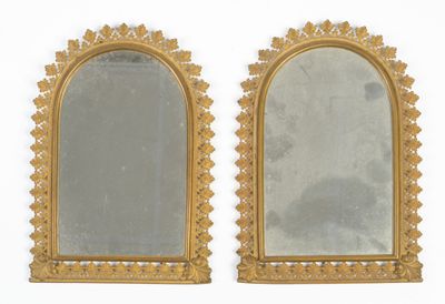 une paire de miroirs à cadre doré accrochés à un mur blanc, sur fond blanc