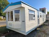 une photo d'un mobil-home garé dans l'herbe