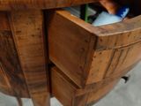 a wooden table with a drawer that has a bottle of wine in it