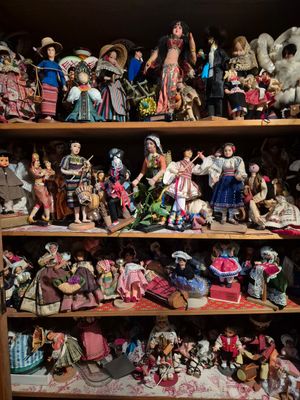 a shelf full of dolls and figurines in a room