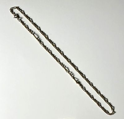 a silver chain with a heart on it on a white surface