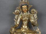 une statue en or représentant une personne assise sur une table