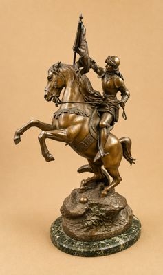 bronze statue of a man on a horse with a flag on its back