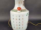 a white vase with asian writing on it on a table