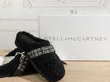 the black slippers are next to a white box on a wooden table