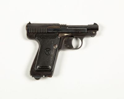 a black gun on a white surface with a white background