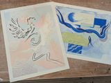 two prints on a wooden table one is a woman and the other is an angel