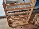 a wooden chair that has a wine rack in it