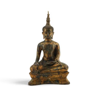 une image représentant une statue d'une personne assise sur un rocher