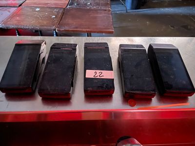several cell phones are lined up on a table in a warehouse