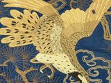 an image of a golden bird on a blue background with clouds