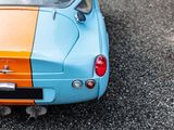 a blue and orange car that is parked in a parking lot