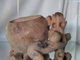 a vase that has a figurine on it