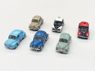 plusieurs petites voitures sont alignées sur une surface blanche