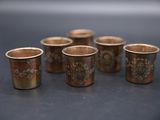 six shot glasses sitting on top of a table next to each other