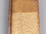 an old book sitting on top of a table next to a white wall
