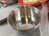 a metal bowl sitting on top of a table next to a pair of scissors