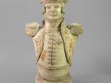 une vieille statue représentant un homme coiffé d'un chapeau