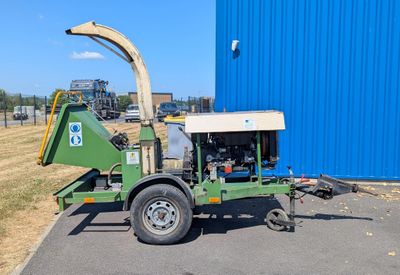 une voiture verte garée devant un immeuble bleu