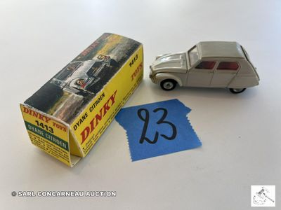 une petite voiture miniature à côté d'une boîte sur laquelle est collé un autocollant