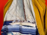 yellow jacket with a sailboat on it hanging on a red wall