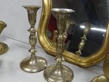 a mirror on the wall behind the gold candlesticks