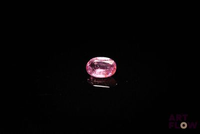 un diamant rose sur une surface noire