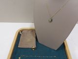 necklace, bracelet, and pouch of jewelry on display on a table