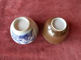 pair of blue and white vases sitting on a red cloth