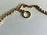 a close up of a gold chain with a ring on it