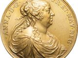 a close up of a gold medal with a woman ' s face