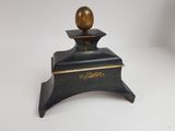 an image of a small wooden box with a gold ball on top