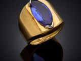 a close up of a gold ring with a blue stone