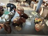 many wooden animals that are on display in a room