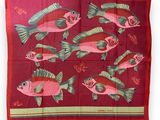 a red scarf with fish and flowers on it