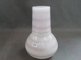 un petit vase blanc orné d'une rayure rose
