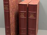 two red books sitting next to each other on top of a table