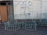 a lot of old metal furniture outside of a building