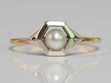 a close up of a ring with a pearl in it
