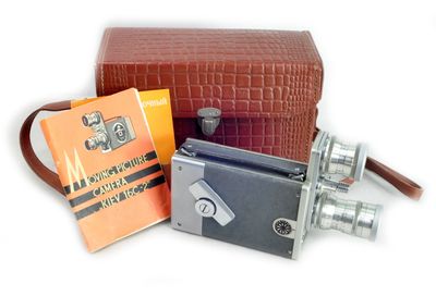 trois types d'appareils photo différents et un livre sur la table