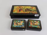 three small boxes with paintings on them sitting on a table