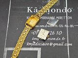 une montre en or et un bracelet en or posés sur une table