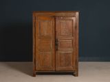 an old wooden cabinet with two doors on top of it